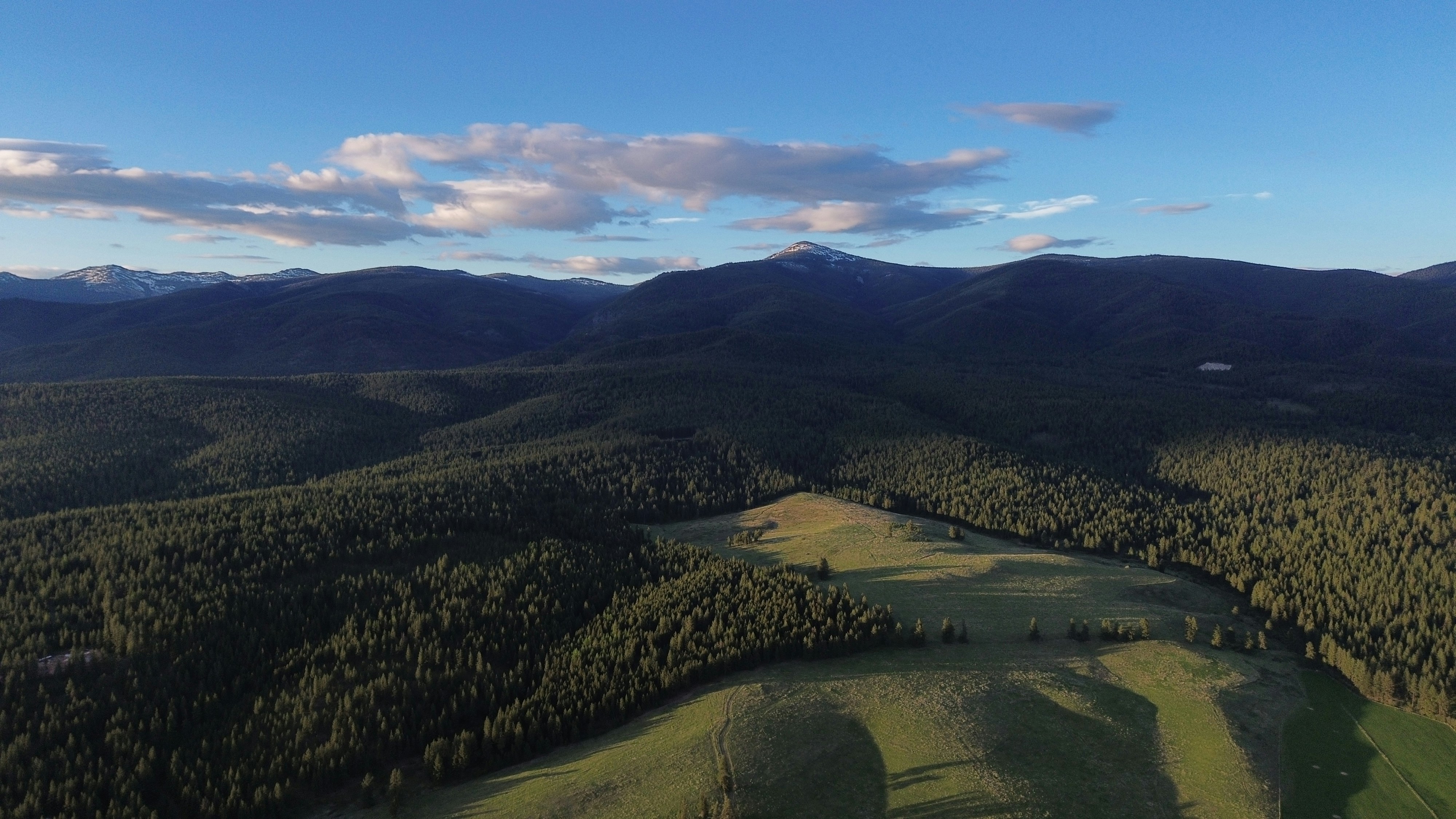 an aerial view of a mountain range with a valley in the foreground