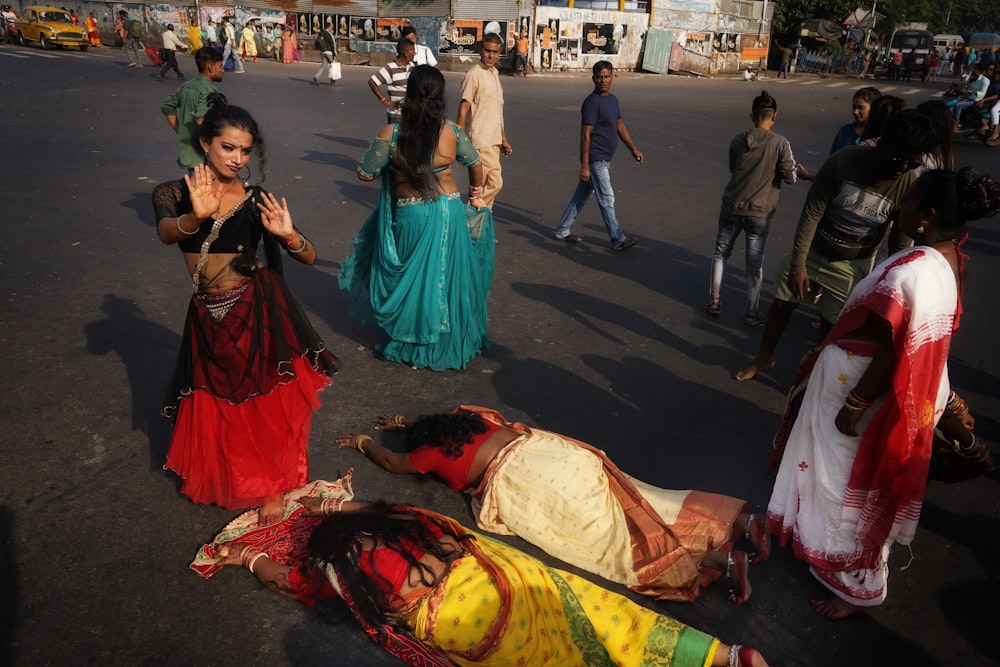 a group of women in colorful saris walking down a street