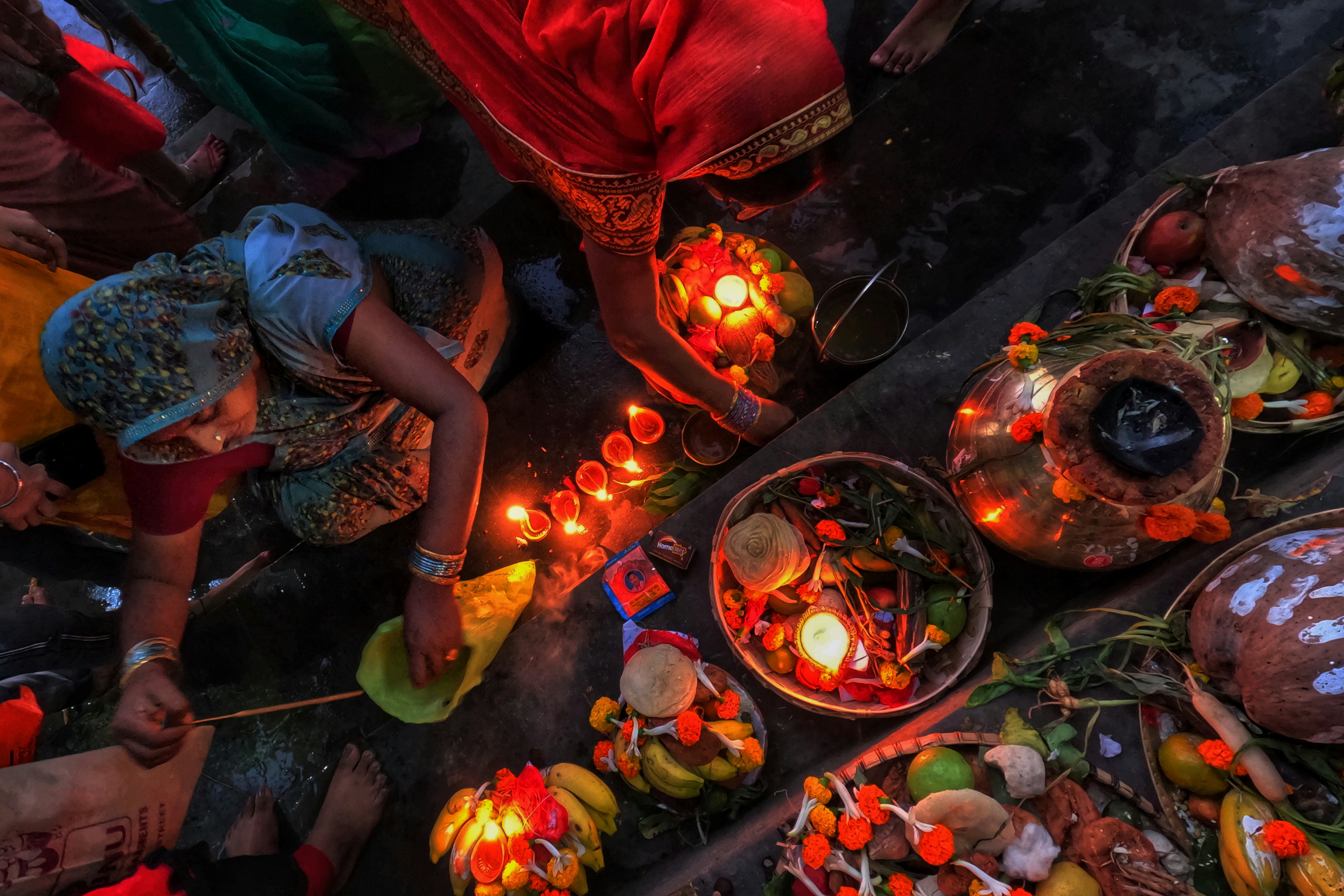 a group of people standing around a table filled with food