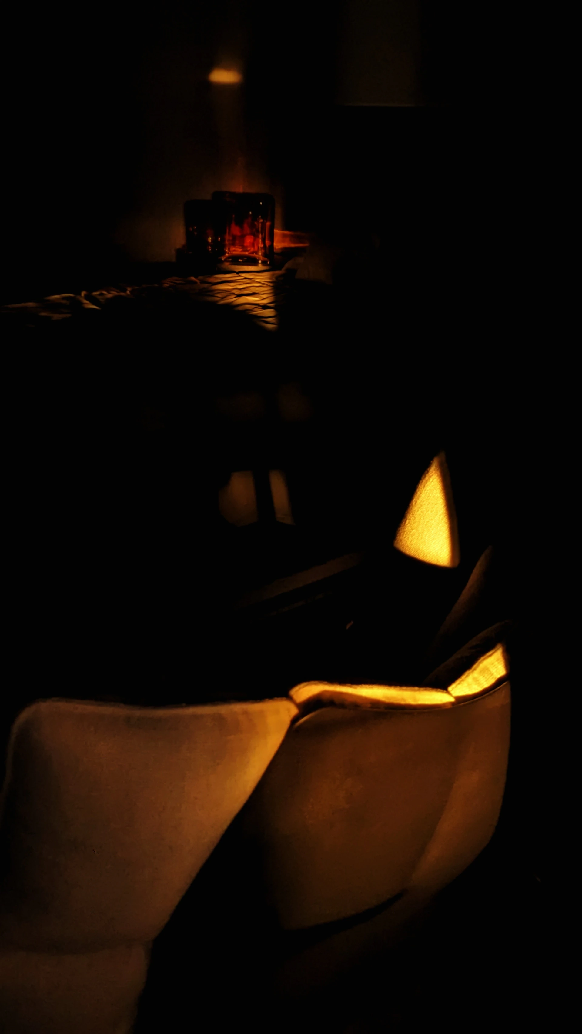a dark room with a chair and a table