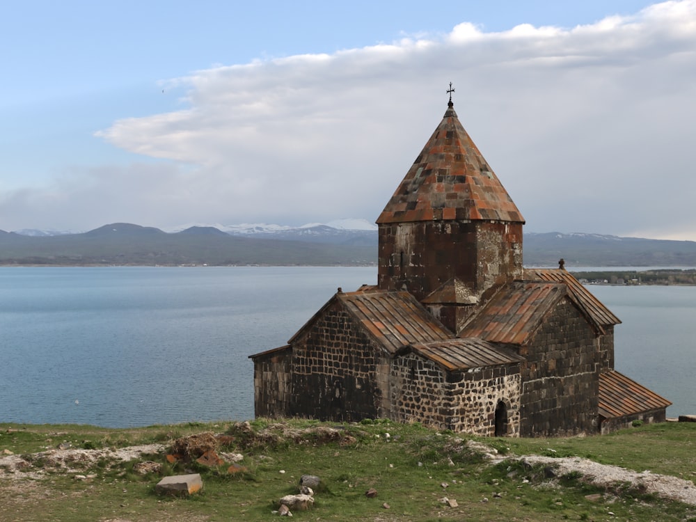 an old church on a hill overlooking a body of water