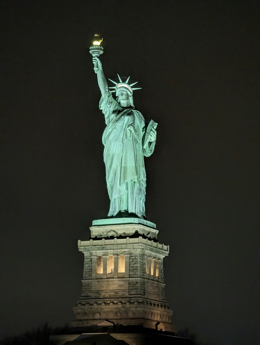 the statue of liberty lit up at night