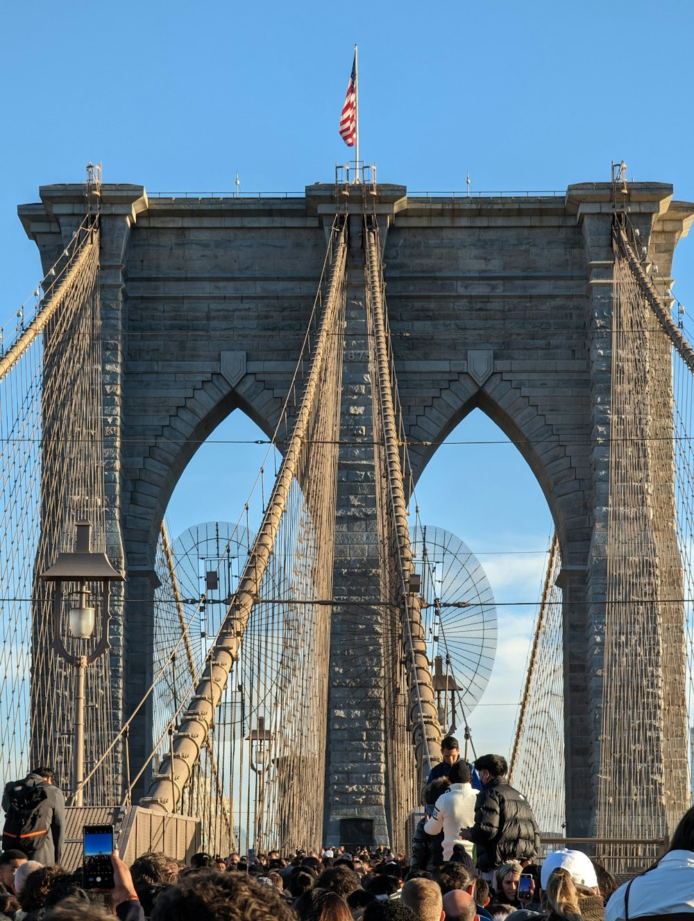 a crowd of people standing on top of a bridge