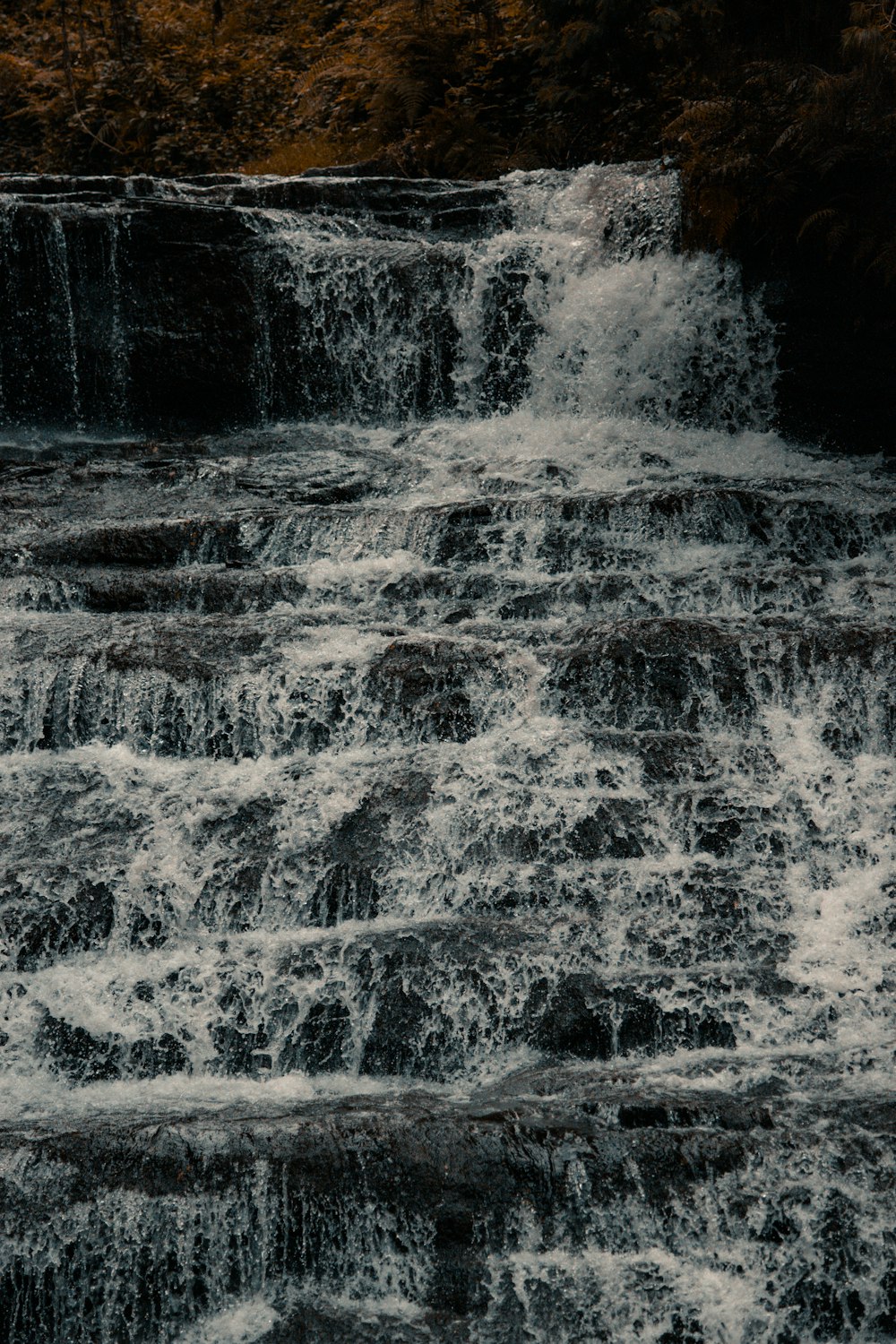 a man riding a surfboard on top of a waterfall