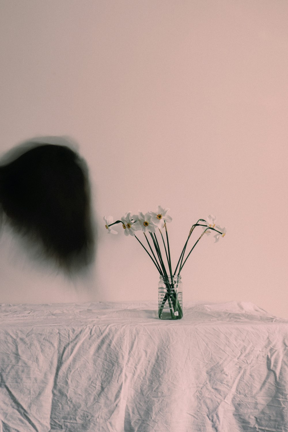 a vase filled with white flowers sitting on top of a table