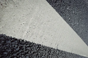 Close-up of yellow directional arrows painted on smooth asphalt road