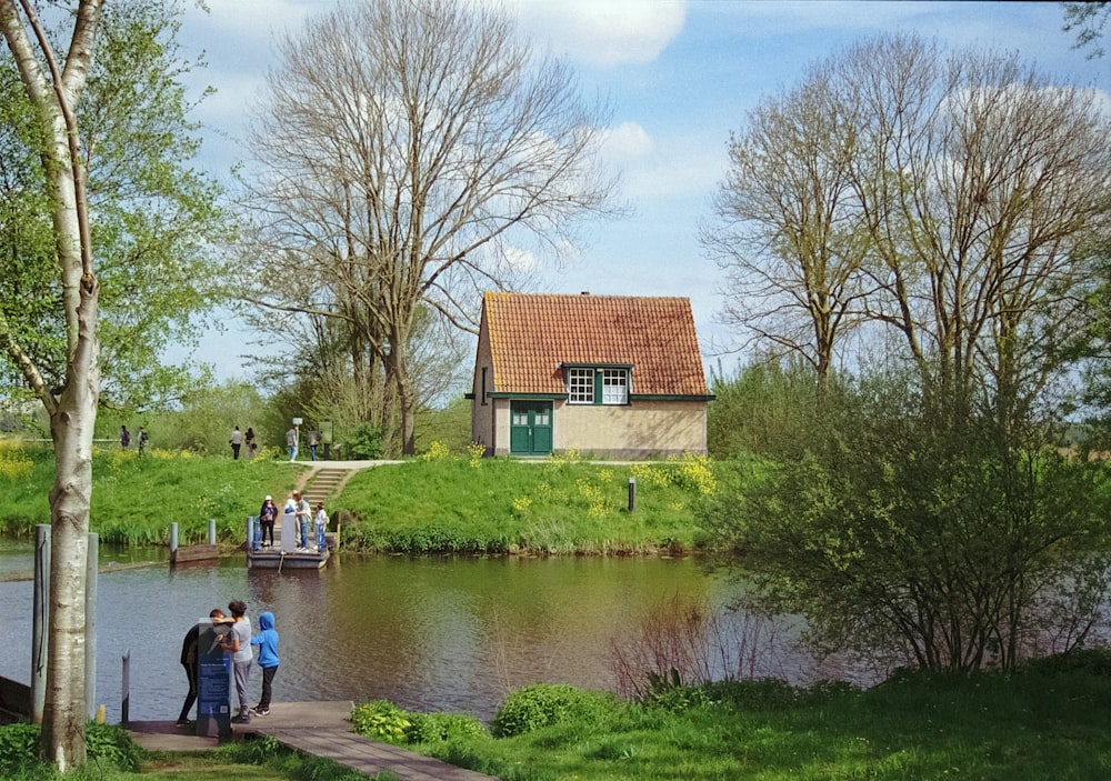 a group of people standing on a dock next to a body of water