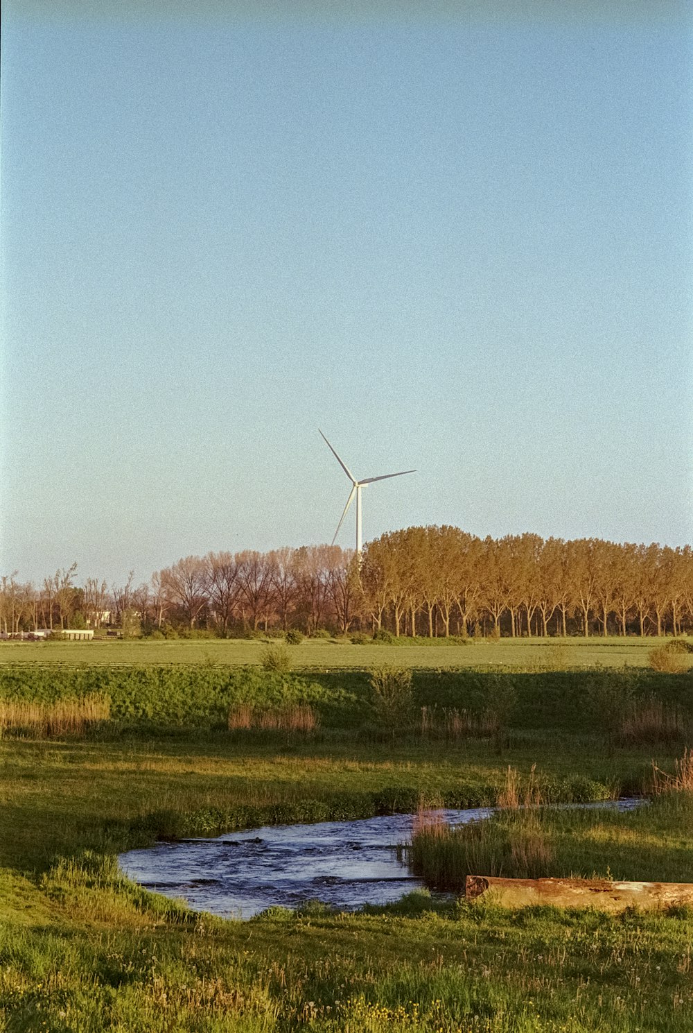 a wind farm with a stream running through it