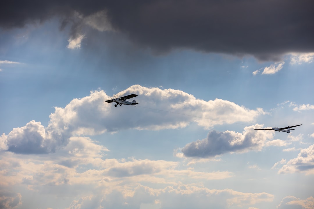 a couple of planes flying through a cloudy sky,