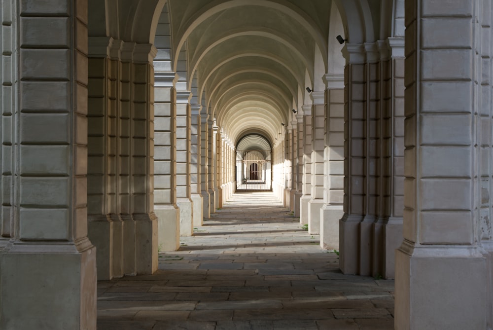 a long hallway with arches and a clock on the wall