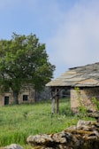 an old stone building with a tree in the background