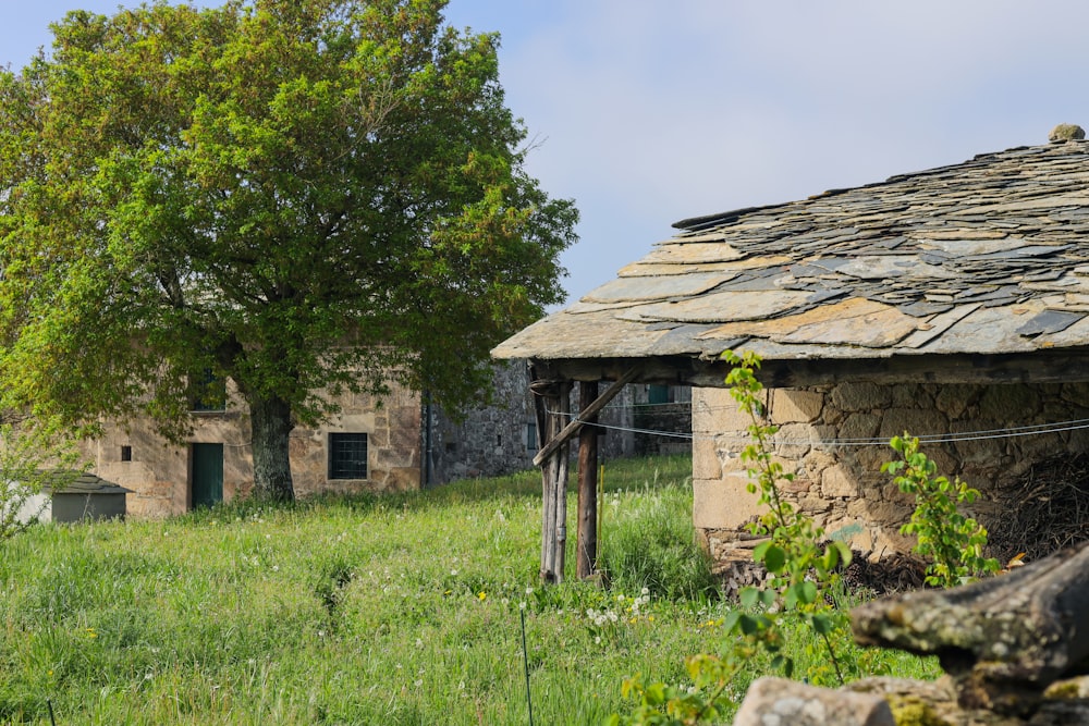 an old stone building in a grassy field