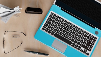 An overhead view of a workspace with business documents, a laptop, and a pen.