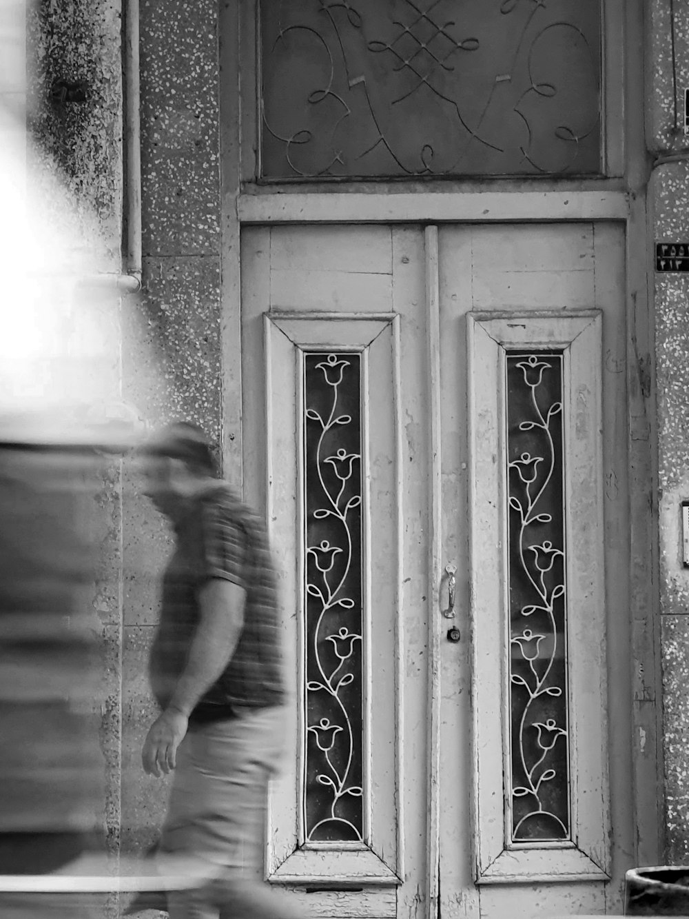 a blurry photo of a man walking past a door