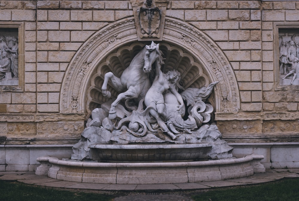 a statue of a horse and two other animals in front of a building