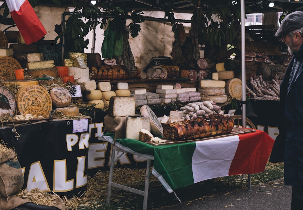 a man standing in front of a display of cheeses