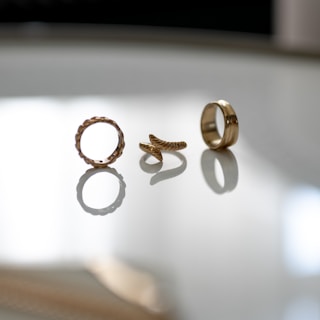 Elegant gold rings stacked together, highlighting intricate designs and shimmering details.