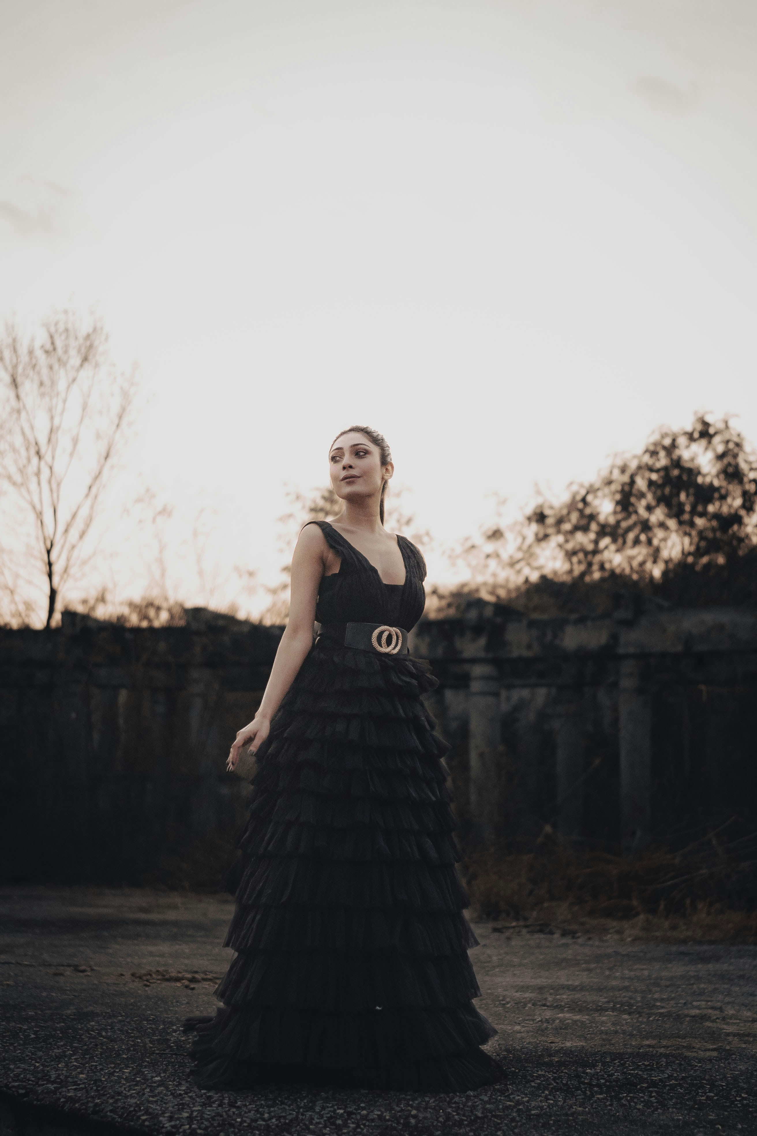 a woman in a black dress standing in a field