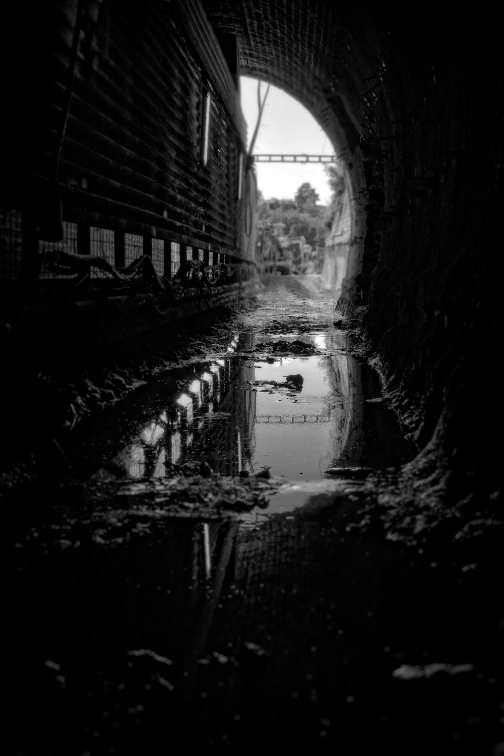 a black and white photo of a dark tunnel