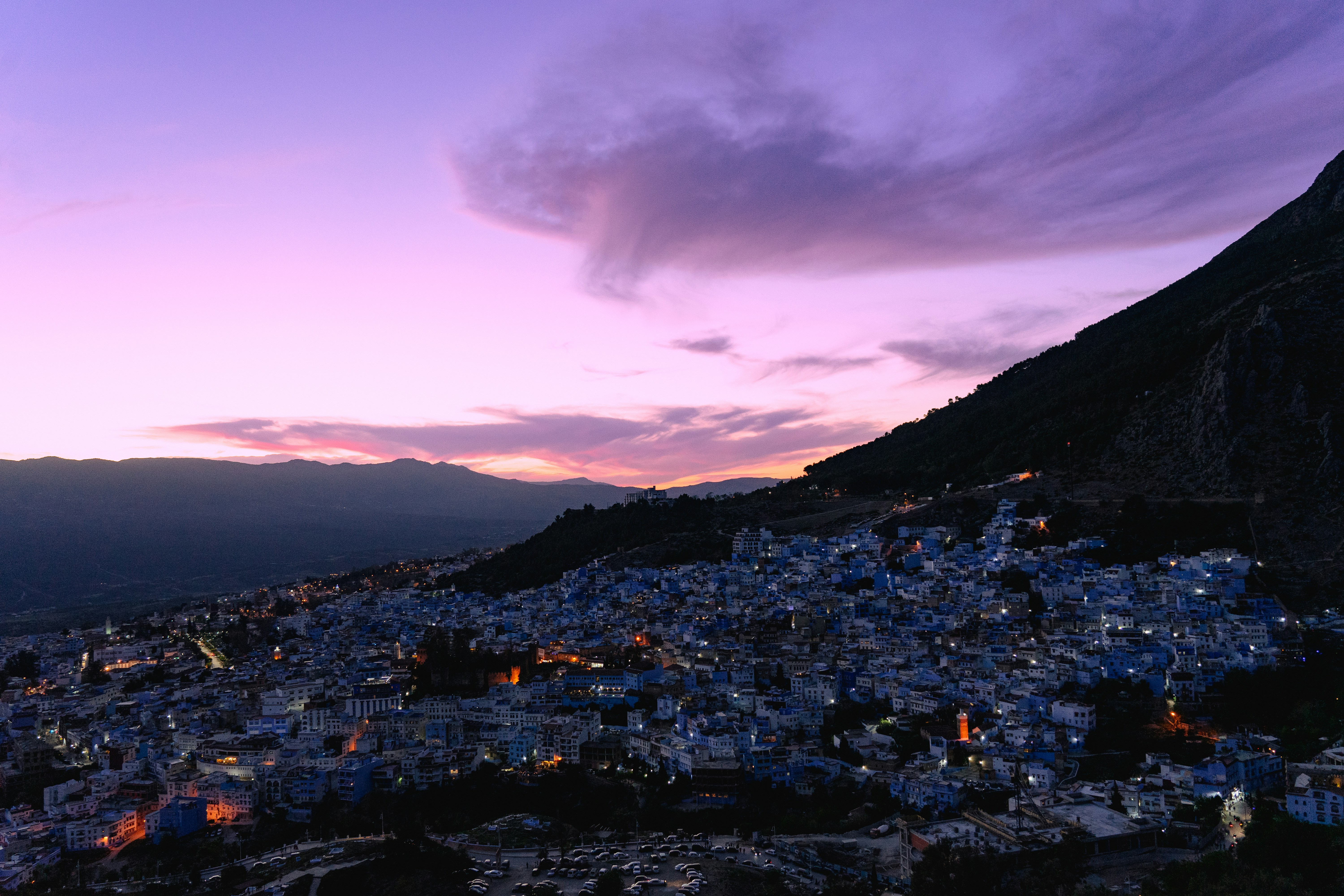A view of a city at dusk from the top of a hill