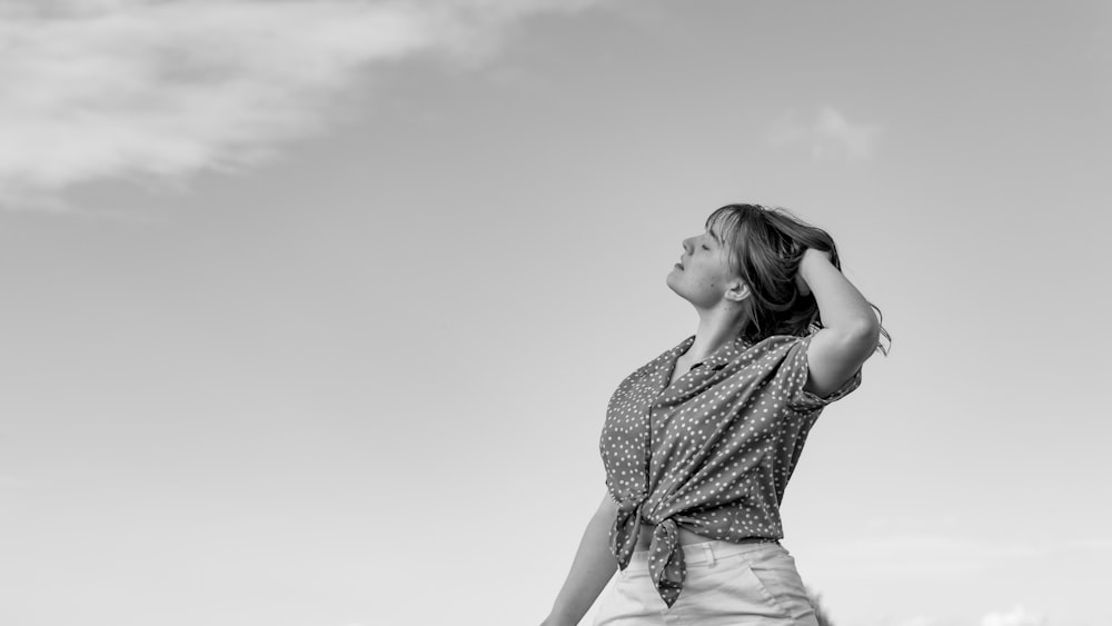 a woman standing in a field holding a frisbee