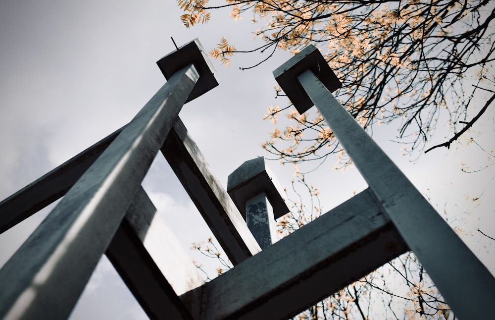 a tall metal sculpture sitting next to a tree