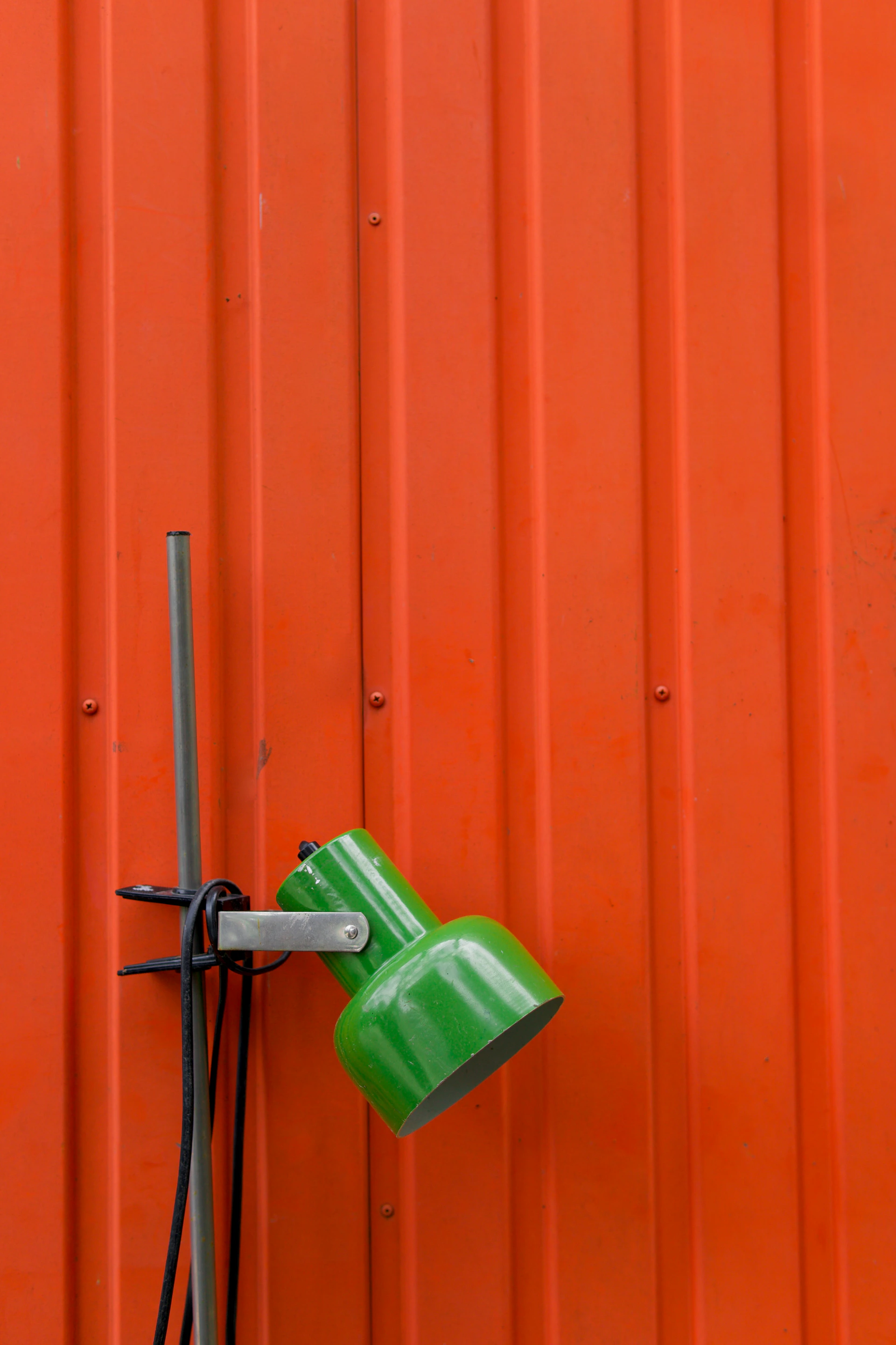 an orange wall with a green lamp on it