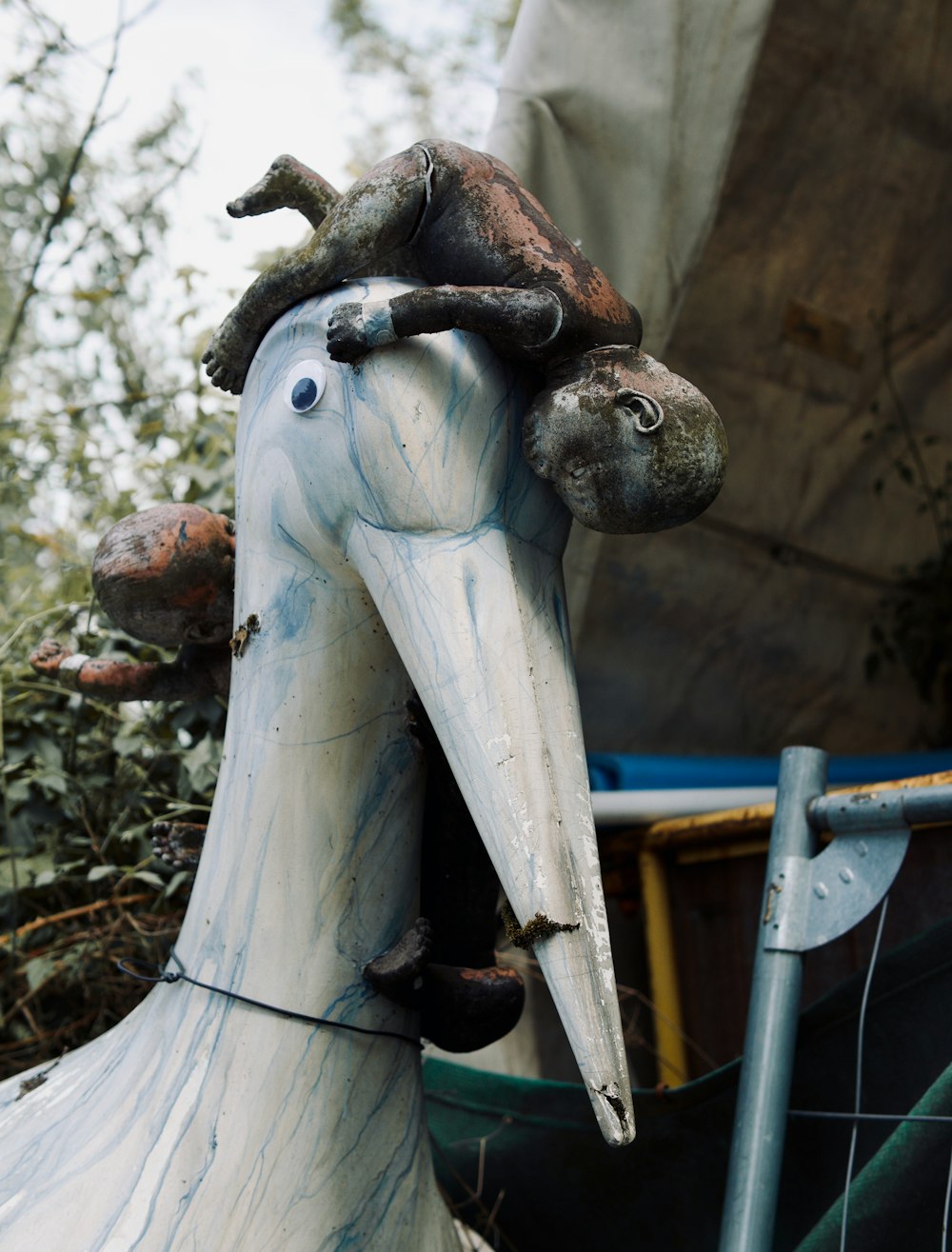 a statue of a bird with a bird on its head