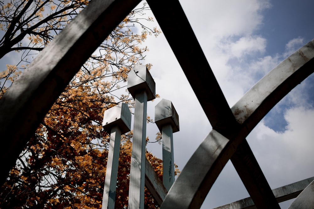 a metal fence with a tree in the background