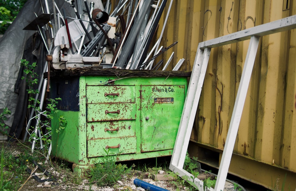 a green cabinet sitting next to a pile of junk
