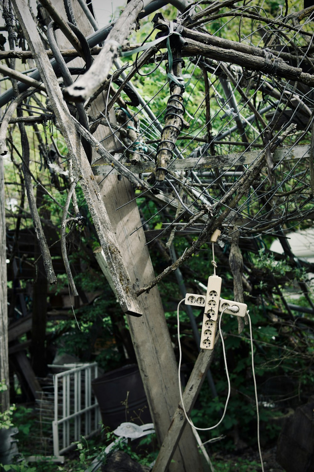 a wooden cross hanging from a tree in a yard