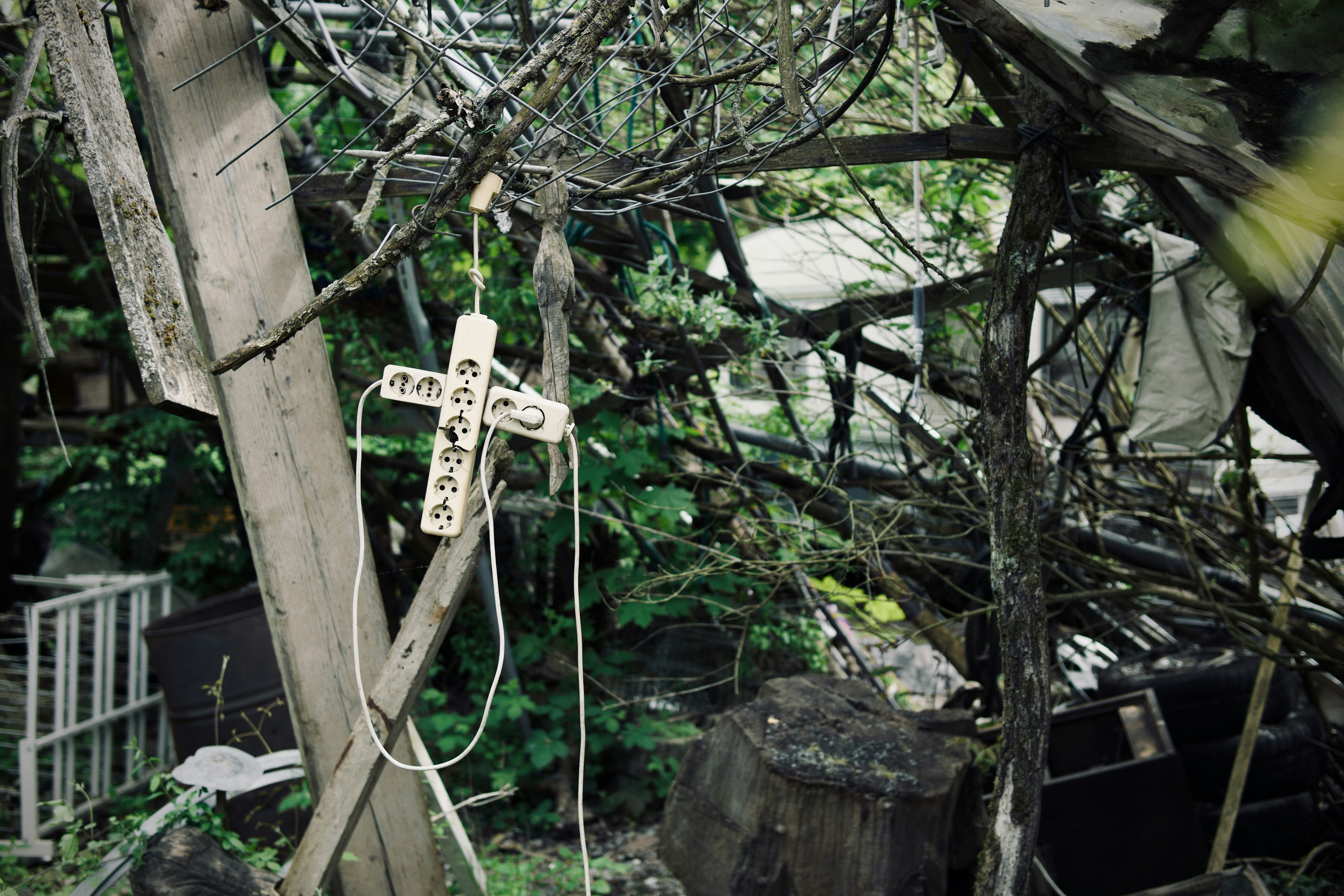 una croce di legno appesa a un albero in un cortile