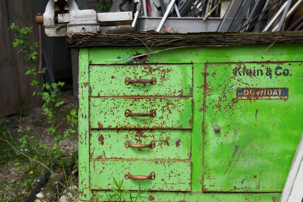 a green cabinet with a bunch of junk on top of it
