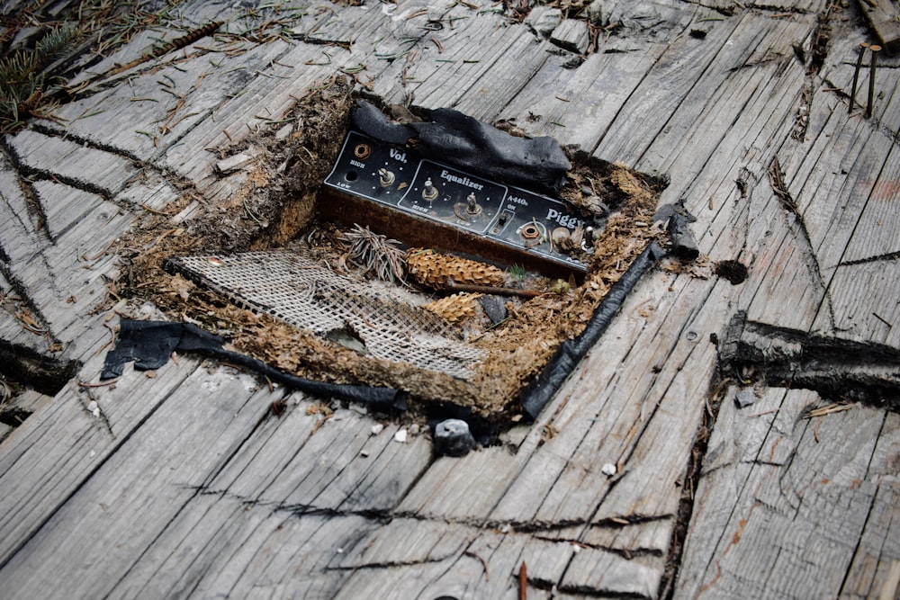 an old radio laying on a piece of wood