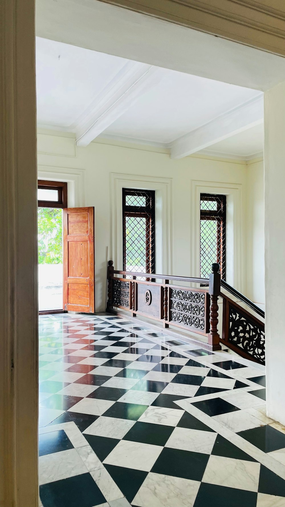 a room with a checkered floor and a wooden door