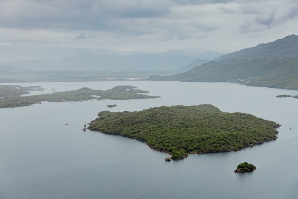 an island in the middle of a lake surrounded by mountains