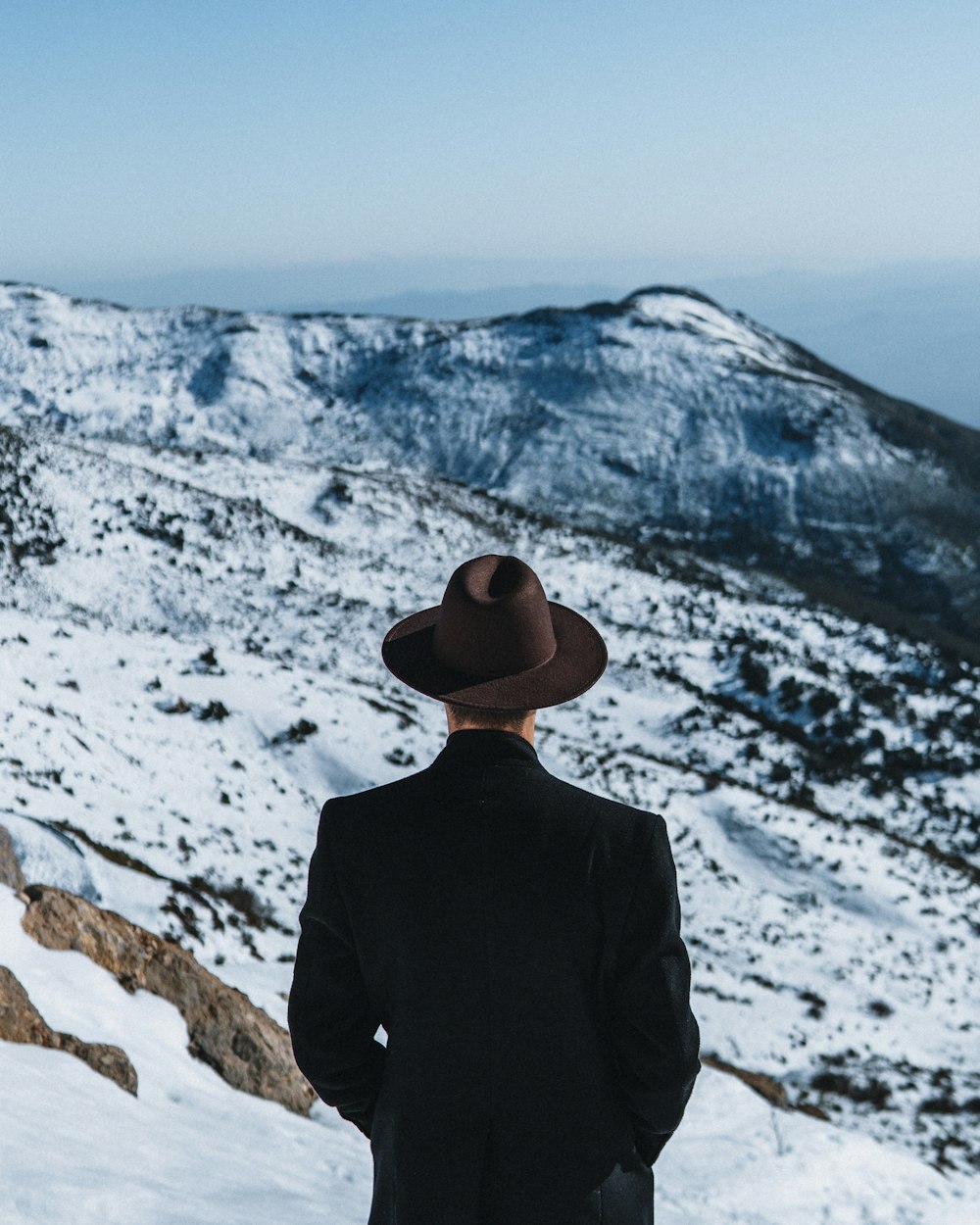 a man standing on top of a snow covered mountain