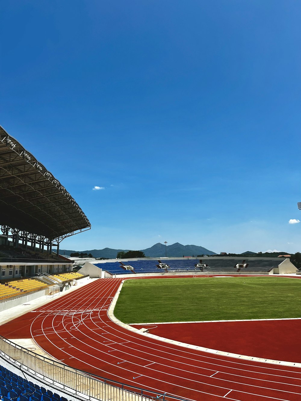 an empty stadium with a red track running through it