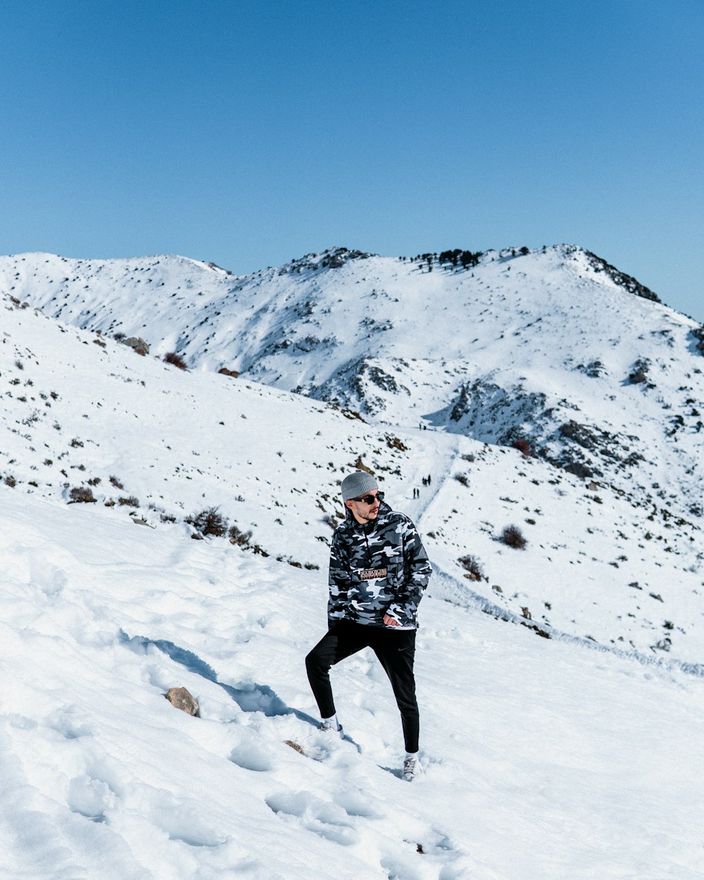 a man standing on top of a snow covered slope