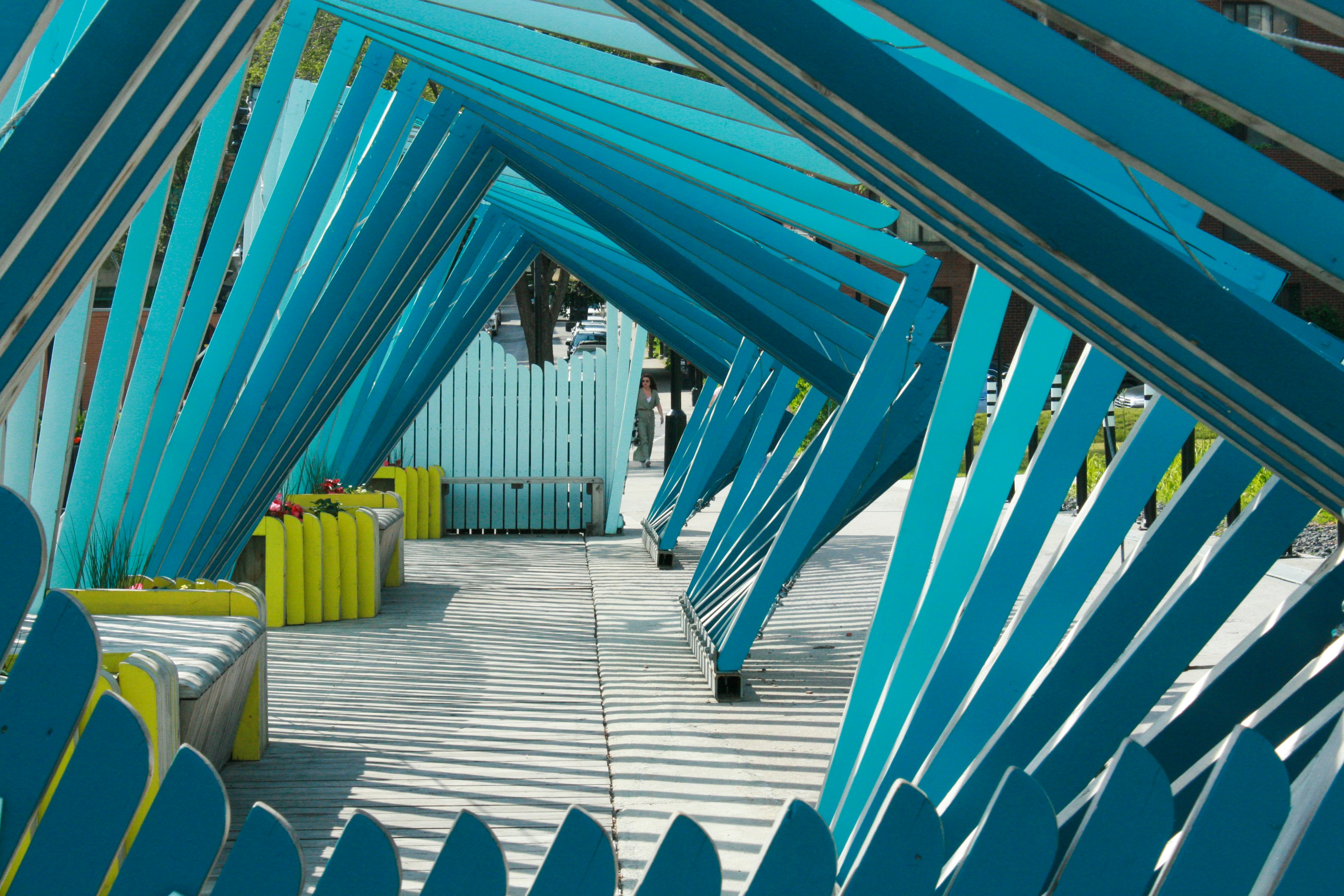 a row of blue and yellow chairs sitting under a roof