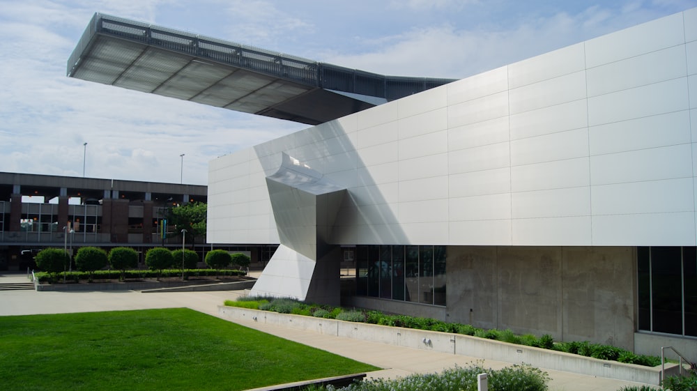 a large white building with a green lawn in front of it