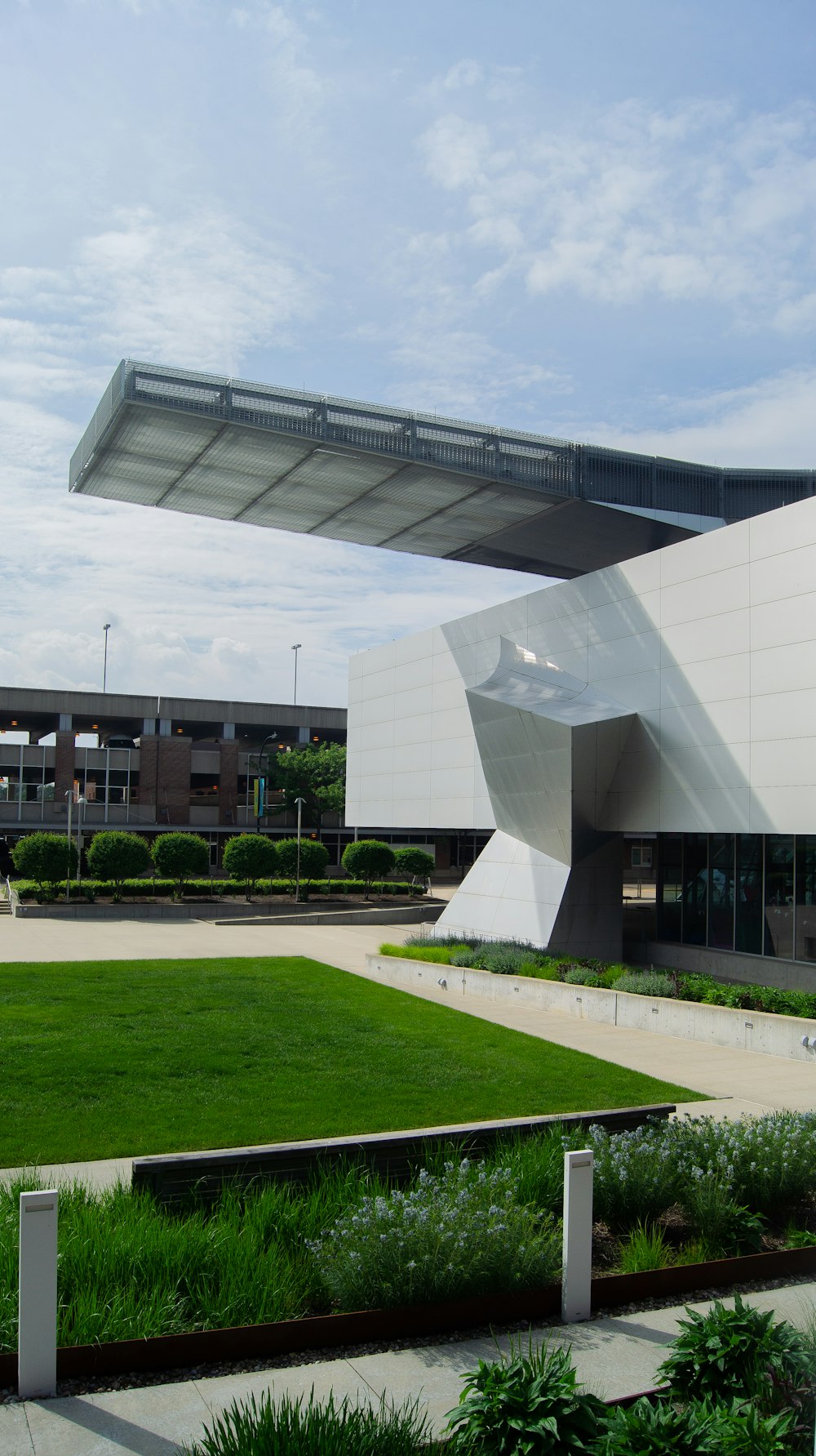 a large white building with a green lawn in front of it