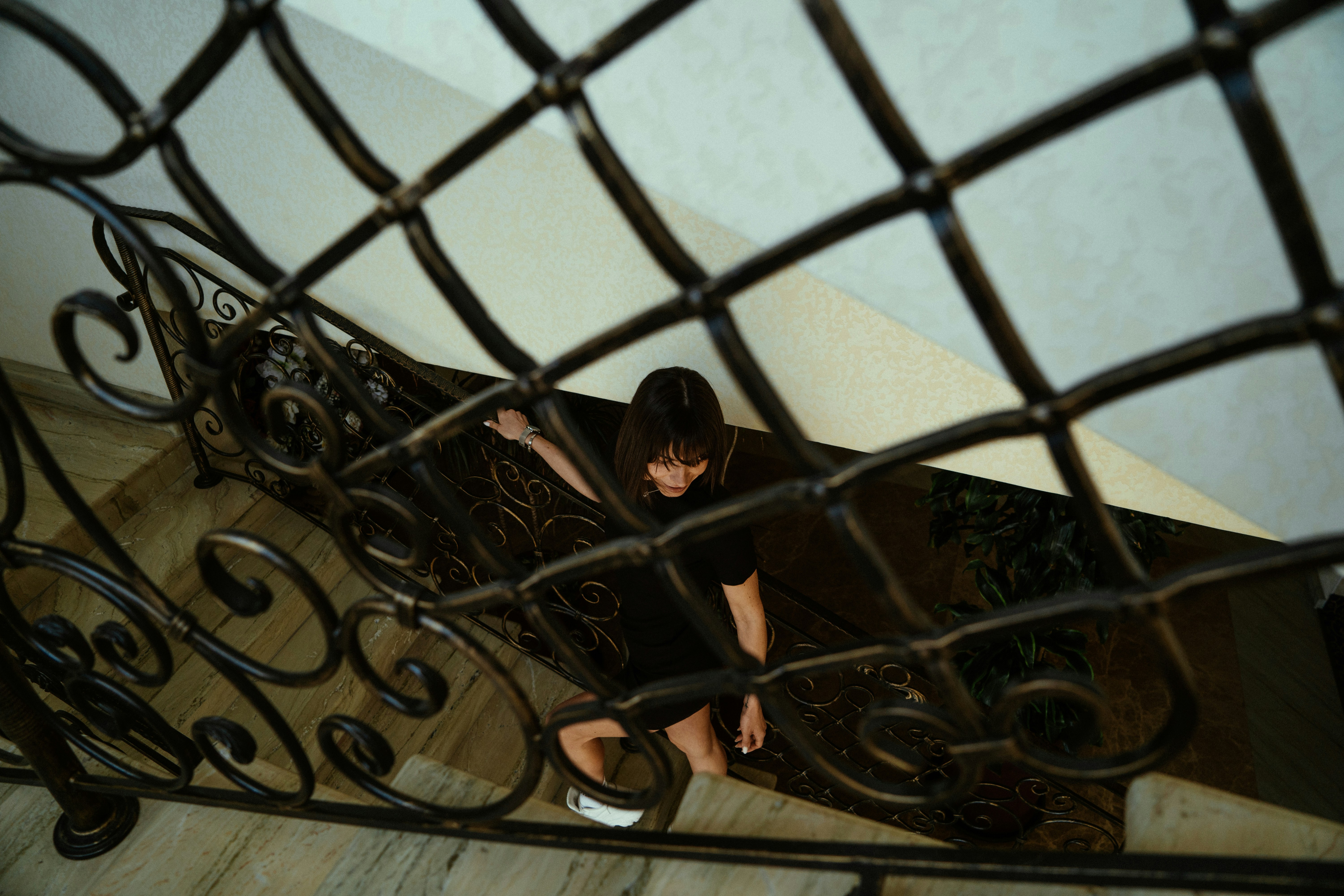 植物の隣の階段ケースに座っている人