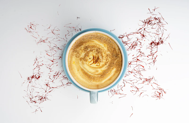 A flat white seen from above, with threads of saffron scattered around the cup