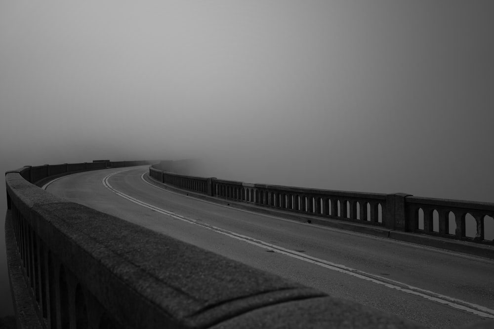 a black and white photo of a foggy road