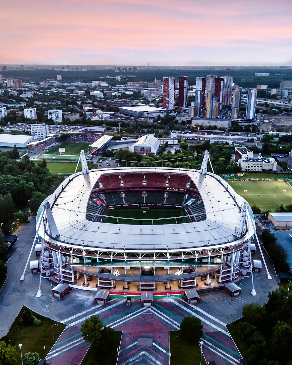 an aerial view of a stadium with a sunset in the background