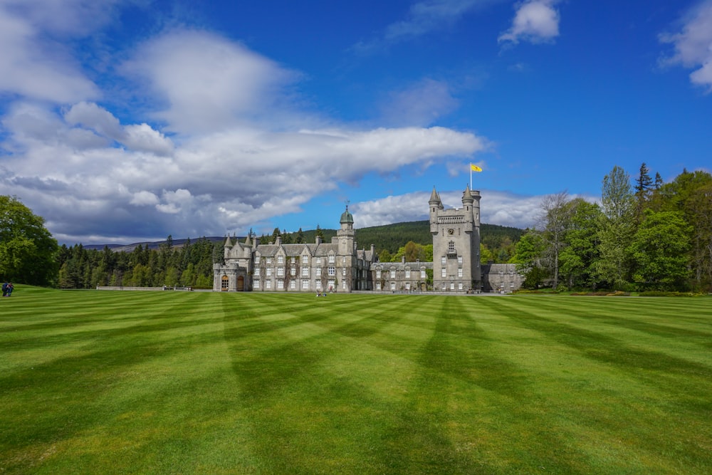 a large castle with a green lawn in front of it