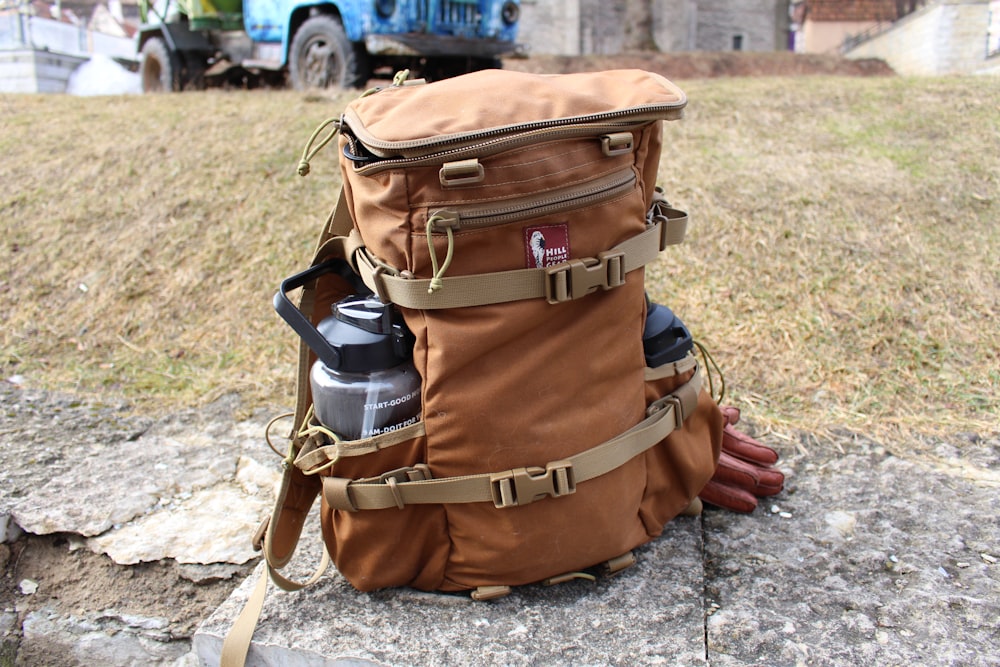 a brown backpack sitting on top of a rock