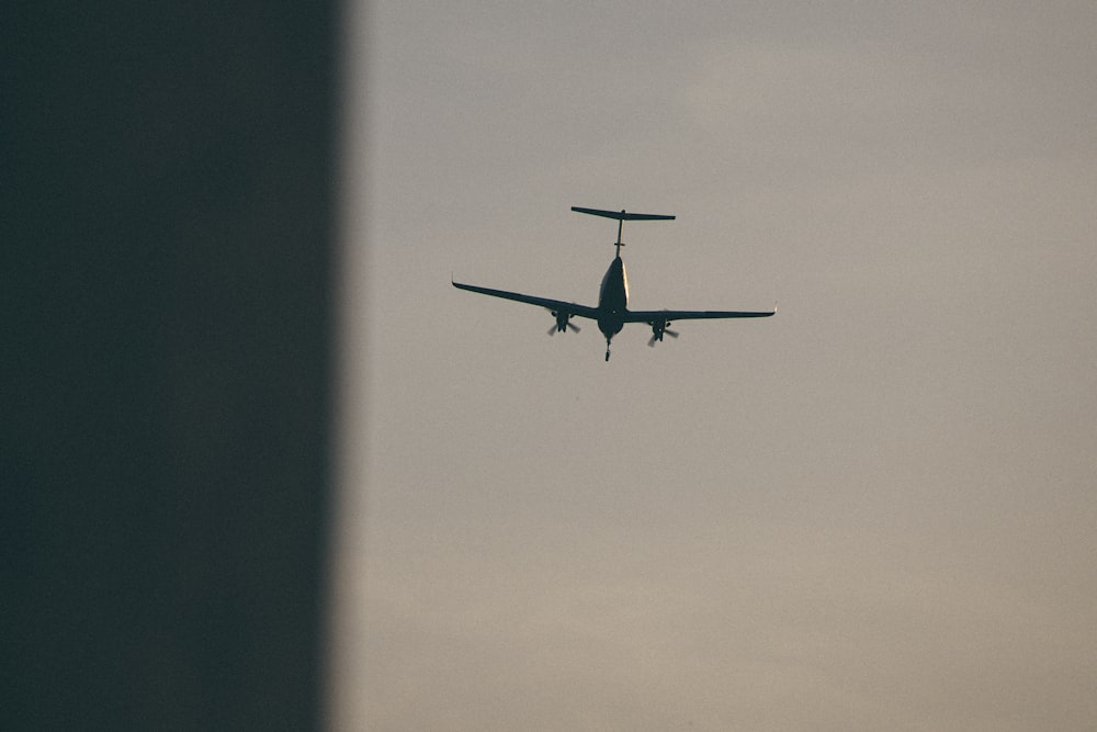 an airplane is flying in the sky with it's landing gear down