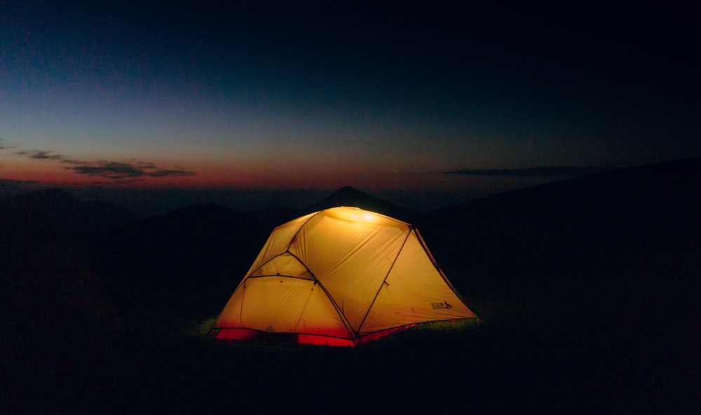 a tent is lit up in the dark